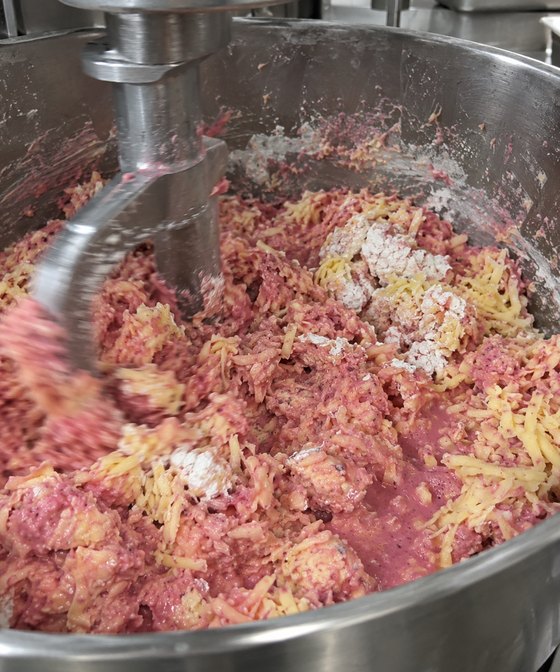 La masa rosa mezclándose con el queso en la batidora